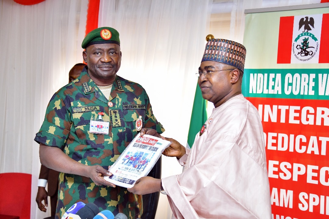 Chairman/Chief Executive Officer of the National Drug Law Enforcement Agency, NDLEA, Brig. Gen. Mohamed Buba Marwa (Retd) presenting a copy of the agency's official magazine to the Chief of Defence Staff, Gen. Christopher Musa when the latter paid him a courtesy visit at the NDLEA's national headquarters in Abuja on Monday 18th December 2023